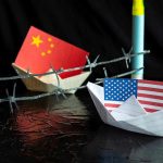 China and USA flags in paper boats with barbed wire
