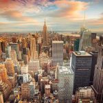 New York City skyline at sunset with tall buildings.