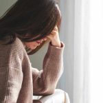 Person with head down, looking distressed or contemplative.