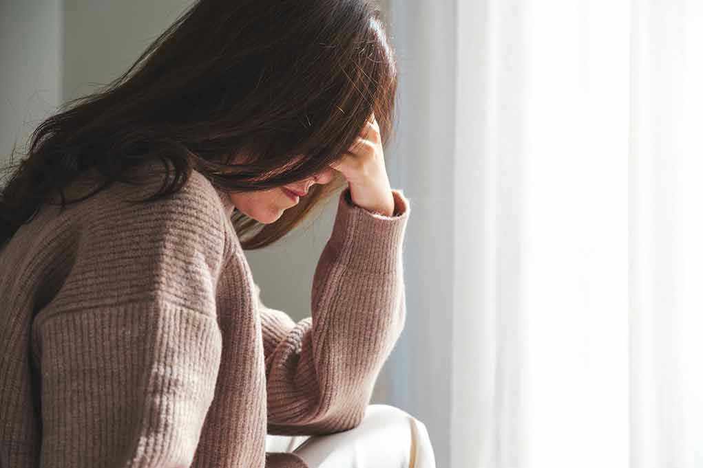 Person with head down, looking distressed or contemplative.