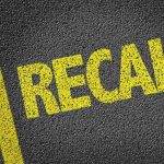 Yellow RECALL text on asphalt background
