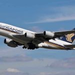 Singapore Airlines airplane taking off against a blue sky