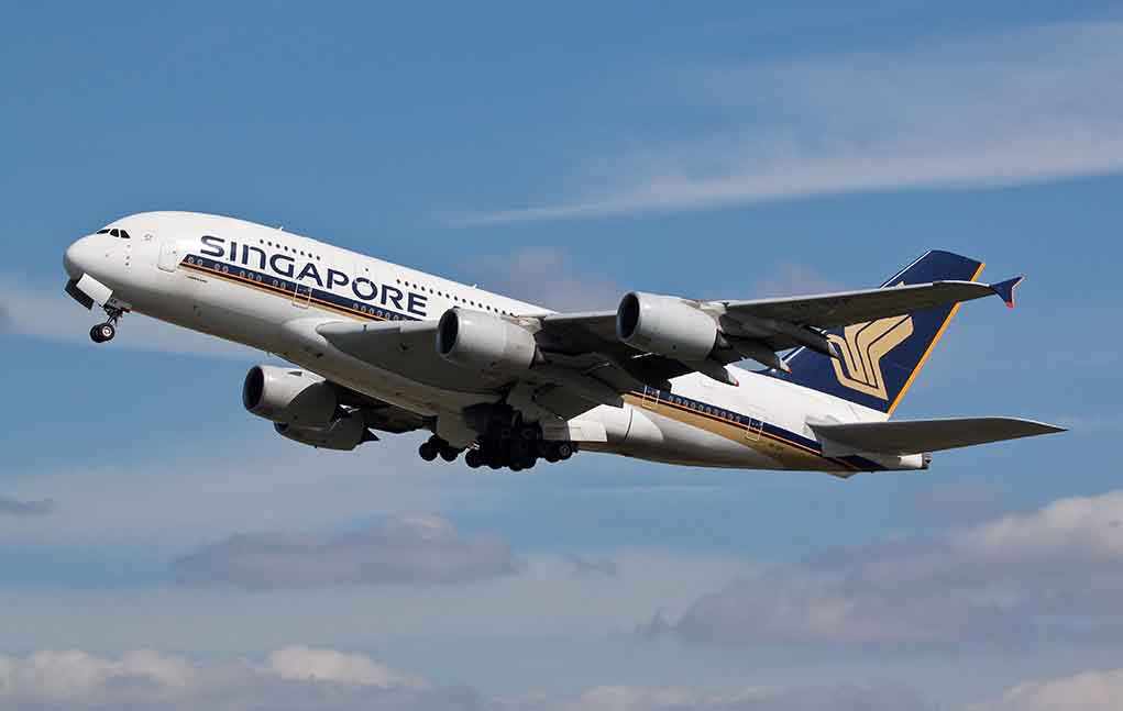 Singapore Airlines airplane taking off against a blue sky