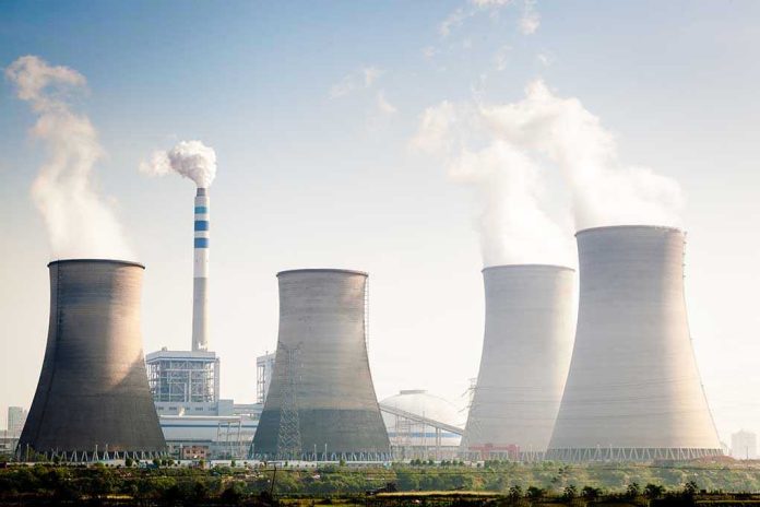 164603351 Four cooling towers of a power plant emitting steam