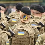 Soldiers in camouflage uniforms with Ukrainian flags