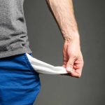 Person pulling out empty pocket from shorts