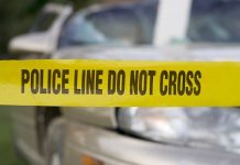 Deadly Crash Ignites Immigration Firestorm Yellow police tape reading POLICE LINE DO NOT CROSS in front of a vehicle