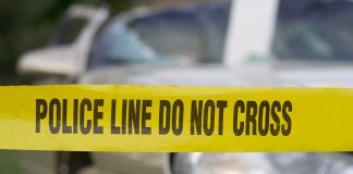 Deadly Crash Ignites Immigration Firestorm Yellow police tape reading POLICE LINE DO NOT CROSS in front of a vehicle