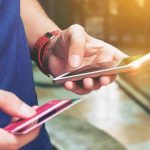 Person holding a smartphone and a credit card, preparing for a digital transaction