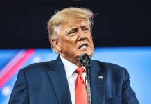 Trump’s Power Play—GOP at Breaking Point Man in suit speaking at a microphone.