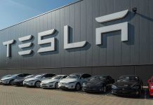 Tesla’s $1 Trillion Mystery: What’s at Stake for Musk? Tesla facility with parked cars in front