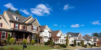 A row of modern suburban houses under a clear blue sky