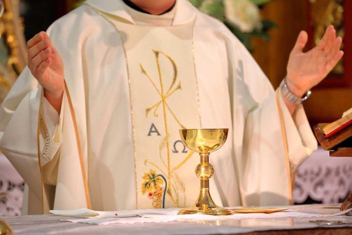 A priest holding a golden chalice during a religious ceremony