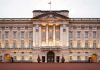Royal Family SHOCK: Meghan’s 2025 Nightmare Front view of Buckingham Palace with illuminated facade and British flag