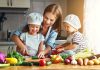 Family cooking together with vegetables in kitchen