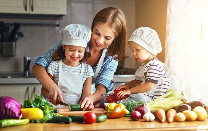 Family cooking together with vegetables in kitchen