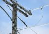 Icy power lines and a utility pole against a blue sky