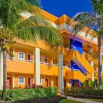 Colorful resort building surrounded by palm trees and lush greenery