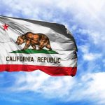 California Republic flag waving against blue sky.