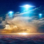 Glowing lights above dramatic sunset clouds.