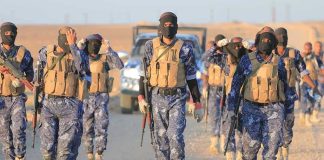 Top ISIS Leader CRUSHED in Secret Raid! Camouflaged soldiers wearing masks and vests walk in desert.