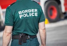 Border Patrol Chief’s MYSTERIOUS Exit—No Answers! Person in Border Police uniform standing outdoors.