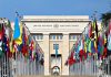 Strait of Hormuz REOPENING? Energy Markets on Edge United Nations building with numerous national flags outside.