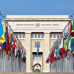 United Nations building with numerous national flags outside.