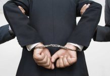 Surgeon Forces Abortion Pills on Girlfriend A person in a suit with hands cuffed behind their back