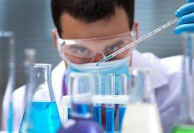 Measles Alert Hits Sewers — Then What? Scientist pipetting blue liquid into test tubes.