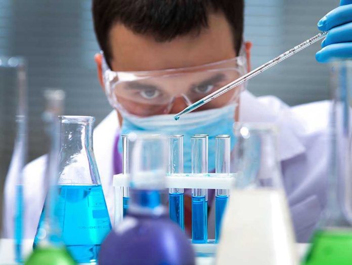 125266409 Scientist pipetting blue liquid into test tubes.