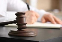 Censorship Backfire: Bureaucrats Now Pay Judges gavel on desk with person writing.