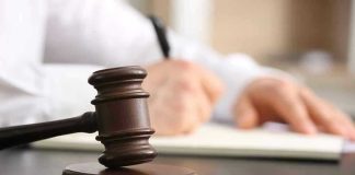 Censorship Backfire: Bureaucrats Now Pay Judges gavel on desk with person writing.
