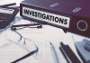 The Political Bet That Triggered Two Federal Investigations Documents and binder labeled Investigations on desk.