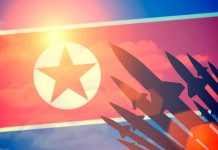 North Korea Claims Nuclear Output Doubled — While Building More Factories North Korean flag with missile silhouettes.
