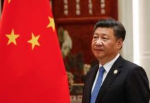 China Claims To Support Denuclearization—So Why The Silence In Pyongyang? A political leader standing beside the Chinese national flag