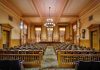 Interior view of a historic courtroom with wooden furnishings and chandeliers