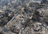 Fireworks Stockpile, Families Homeless Aerial view of a neighborhood devastated by wildfire, showing burned structures and debris