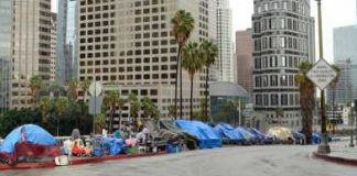 One-Way Bus Tickets in 1996. Trash Trucks in 2026. Same City. Row of tents along a city street with skyscrapers in the background