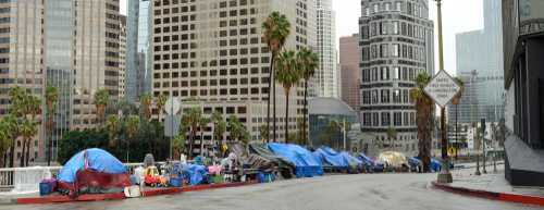 shutterstock_1469142698 Row of tents along a city street with skyscrapers in the background