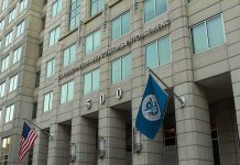 Unchecked ICE Patrols Spark Panic U.S. government building facade with American and blue departmental flags