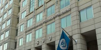 Unchecked ICE Patrols Spark Panic U.S. government building facade with American and blue departmental flags
