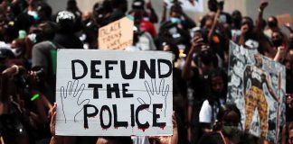 Protester holding a sign at a crowded demonstration