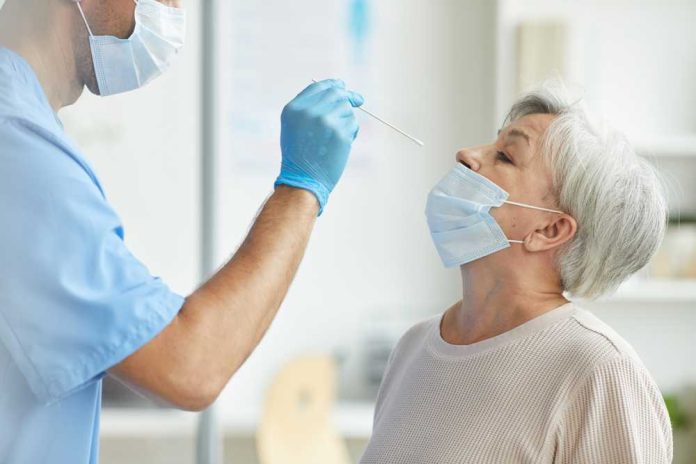 shutterstock_1807704580 Healthcare worker administering a nasal swab test to an elderly woman