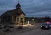 Police and forensic team at a crime scene near an abandoned church in the desert