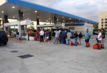America’s Fuel Cushion Evaporates Fast People waiting in line at a gas station with fuel containers