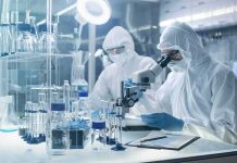 New Tests Flag Abortion Drug Byproducts Scientists in protective suits using a microscope in a laboratory