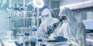 New Tests Flag Abortion Drug Byproducts Scientists in protective suits using a microscope in a laboratory