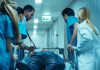 Medical team rushing patient on a gurney through hospital corridor