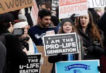 Group of protesters holding pro-life signs at a rally